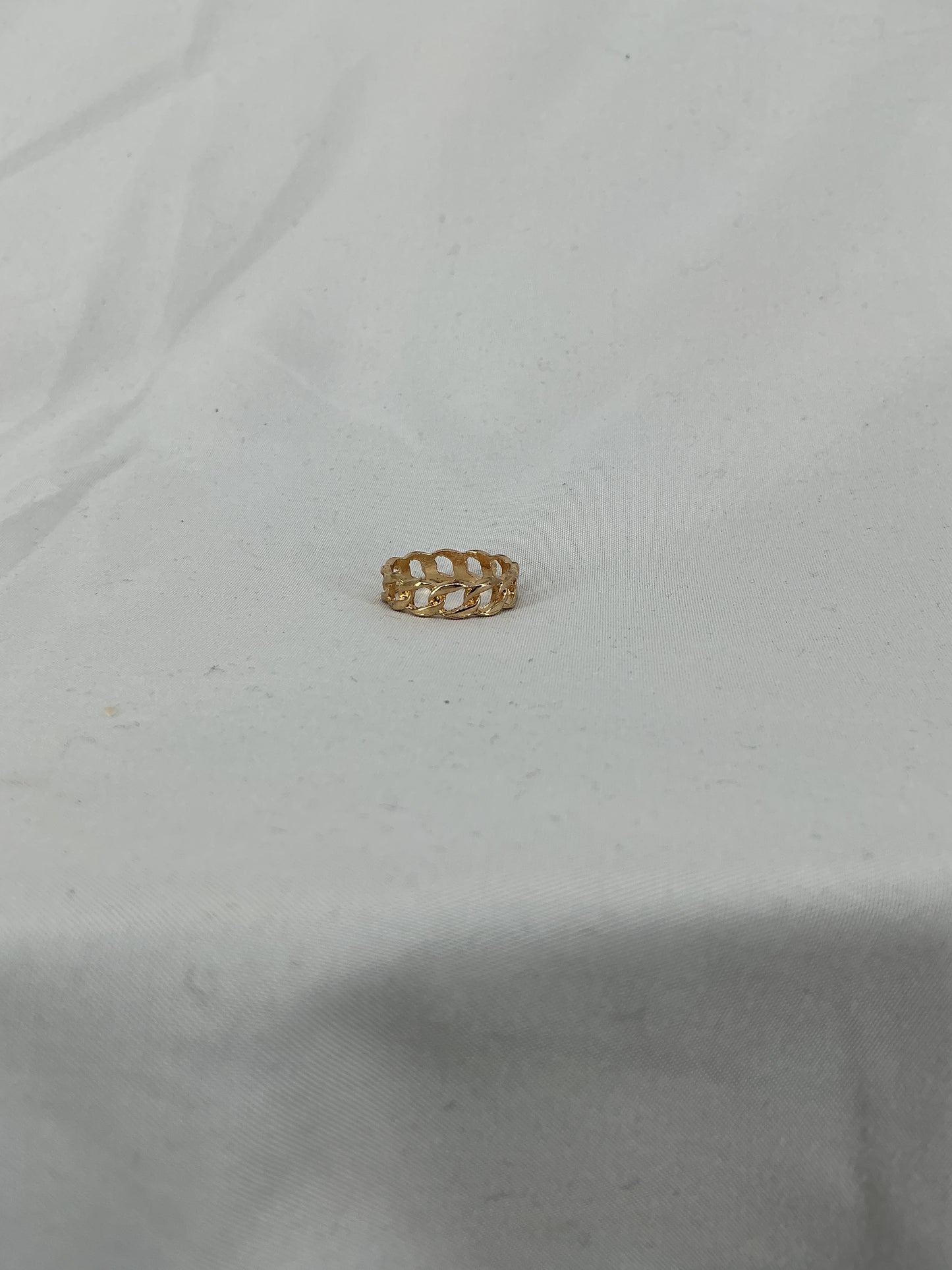 A gold ring, designed in a chain (Cuban link) style with an open-ended design.