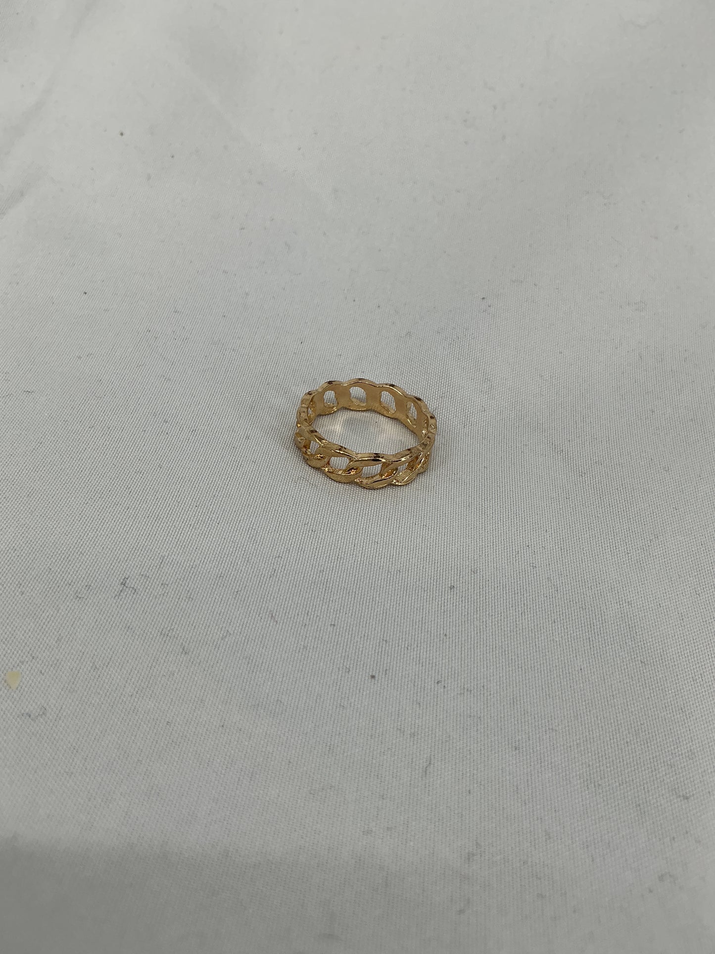 A gold ring, designed in a chain (Cuban link) style with an open-ended design.