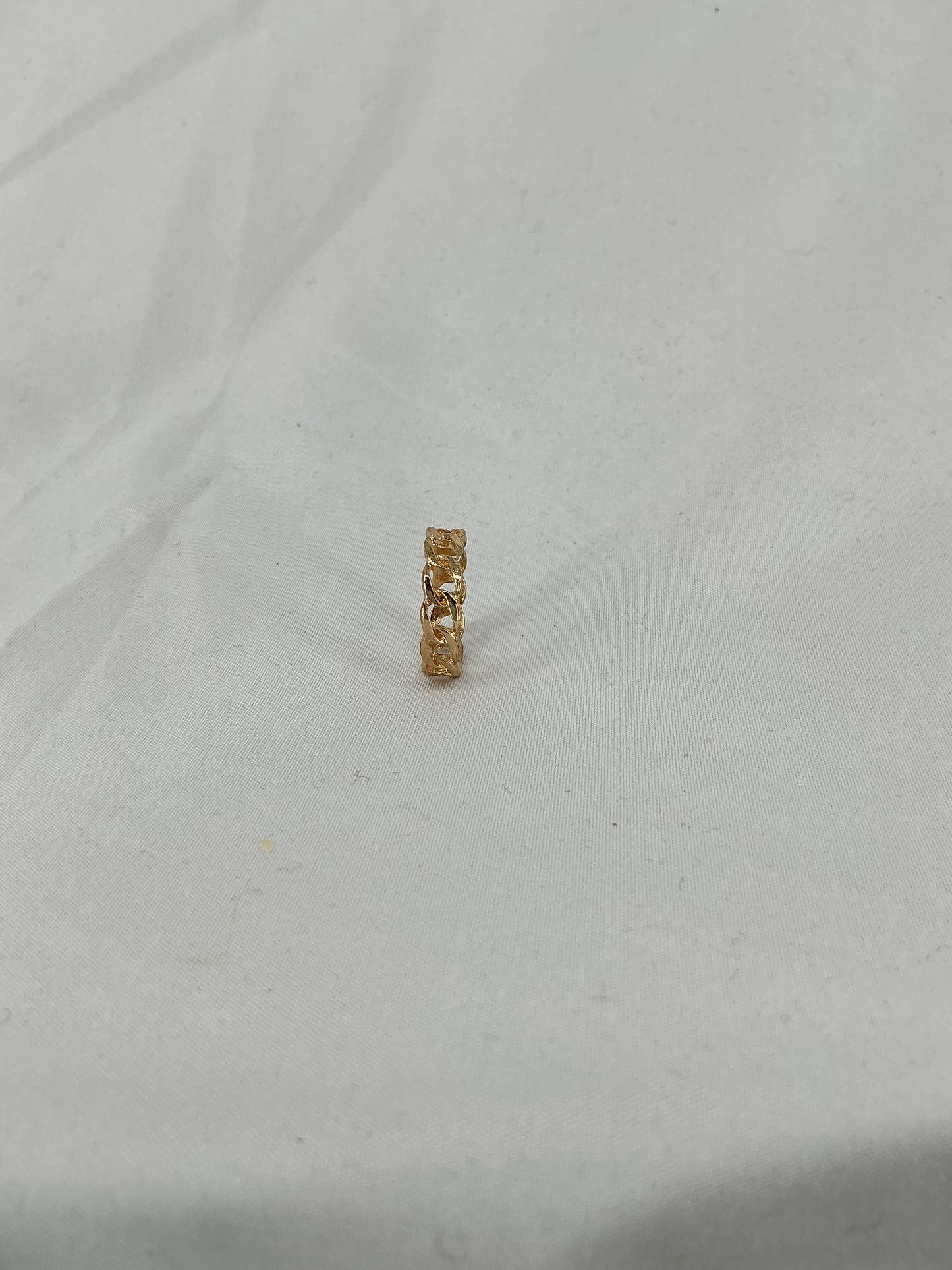 A gold ring, designed in a chain (Cuban link) style with an open-ended design.