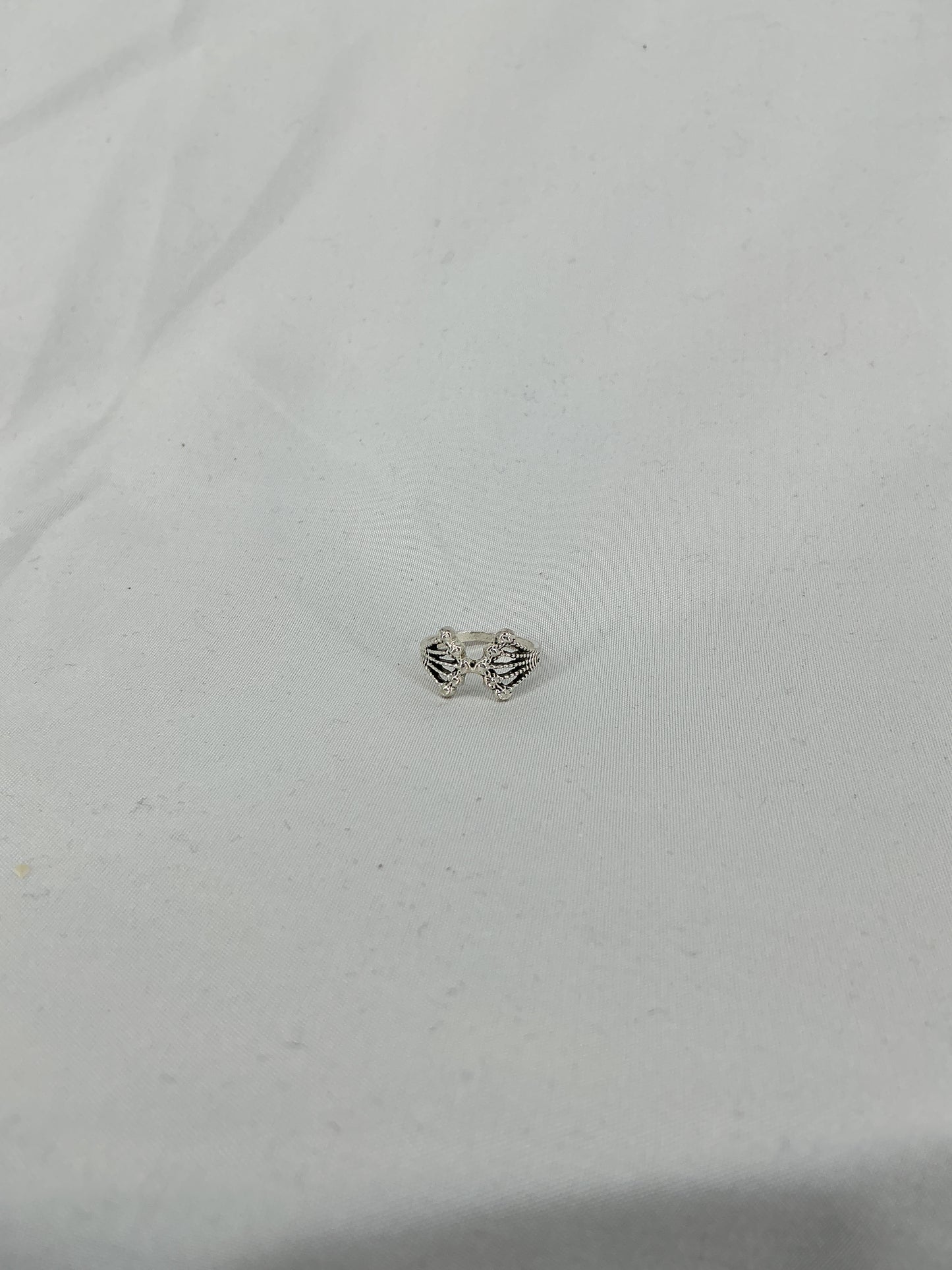 A silver ring, a crown/fan-shaped openwork design with inlaid stones.
