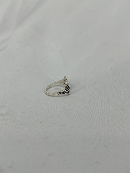 A silver ring, a crown/fan-shaped openwork design with inlaid stones.