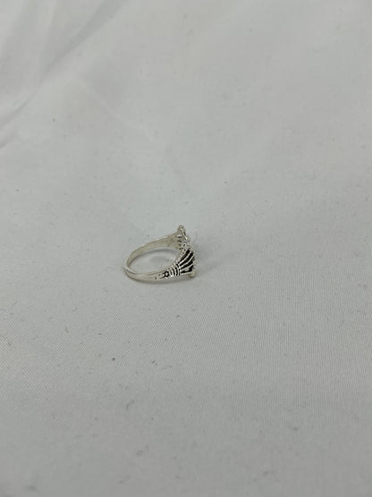A silver ring, a crown/fan-shaped openwork design with inlaid stones.