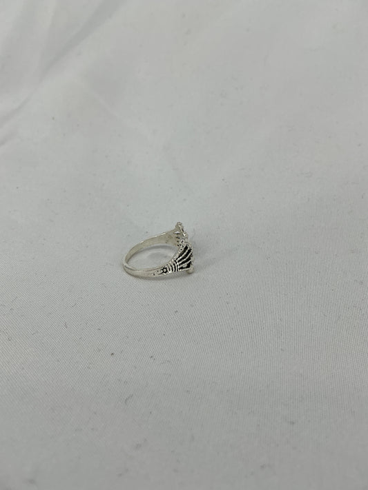 A silver ring, a crown/fan-shaped openwork design with inlaid stones.