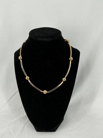 Necklace made of gold-colored beads and rectangular tubes.