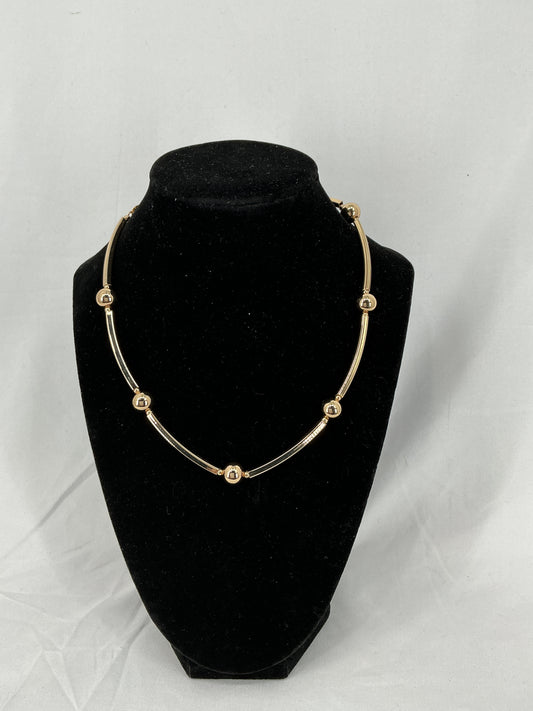 Necklace made of gold-colored beads and rectangular tubes.