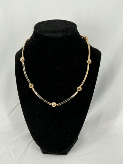 Necklace made of gold-colored beads and rectangular tubes.